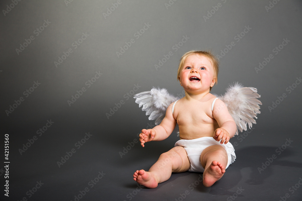 Infant baby with angel wings on neutral background Infant baby with angel wings on neutral background