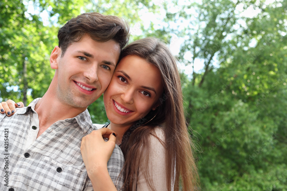 Naklejka premium Smiling young man and woman stand in park;