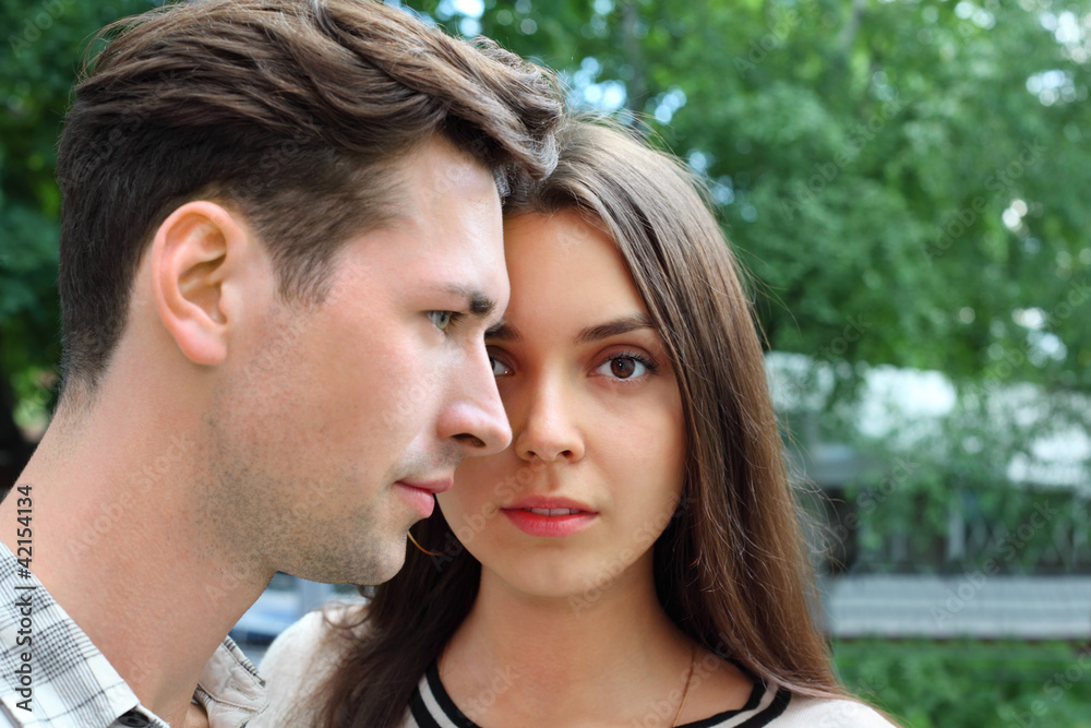 Beautiful pensive man and woman stand in park; Beautiful pensive man and woman stand in park;