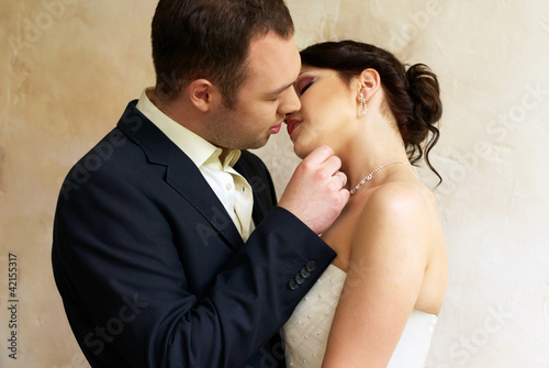 groom kisses bride in empty room