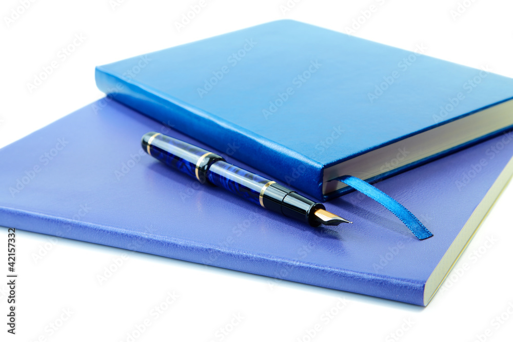 Dark blue writing-books and fountain pen isolated on a white Dark blue writing-books and fountain pen isolated on a white