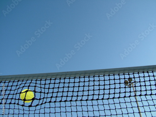 Tennis ball in the net © flik47