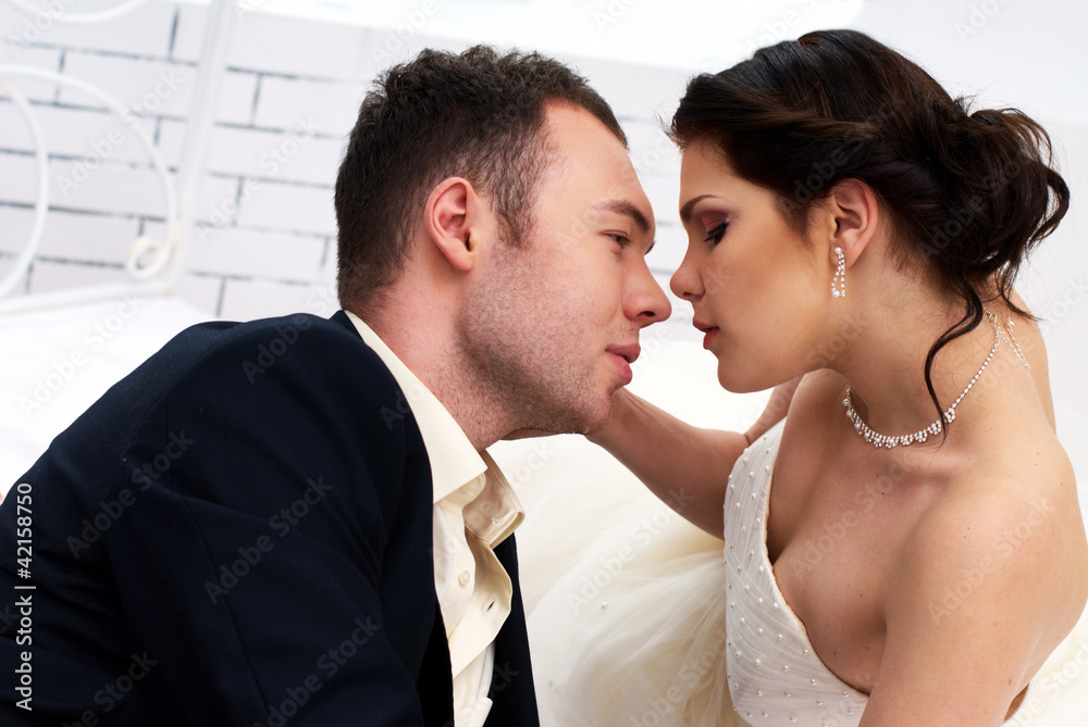 bride and groom lying in bedroom with orchids bride and groom lying in bedroom with orchids