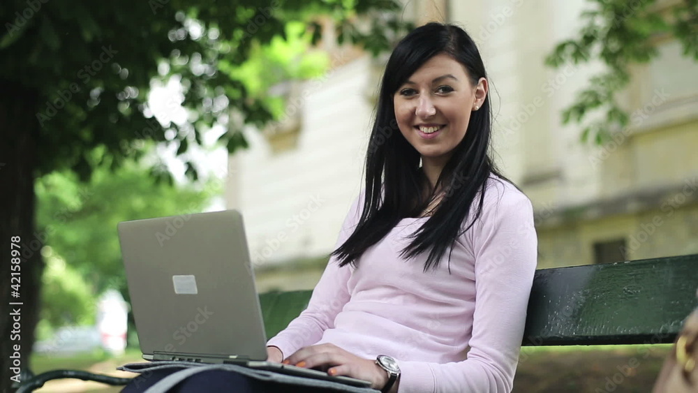 Young happy girl with laptop in the city park Young happy girl with laptop in the city park
