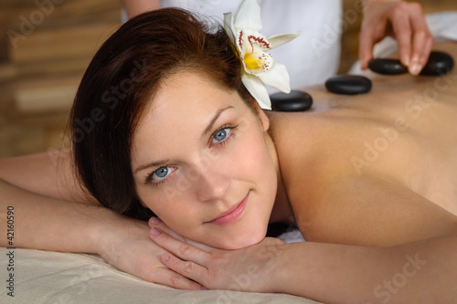 Woman enjoy hot lava stone massage spa photo