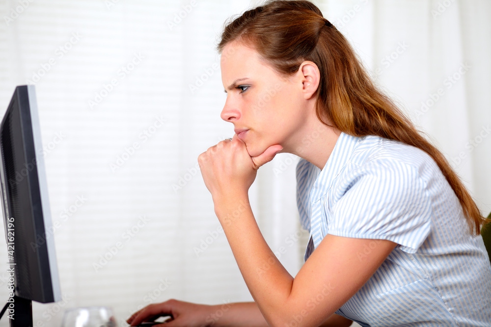 Charming pensive pretty girl looking on computer Charming pensive pretty girl looking on computer