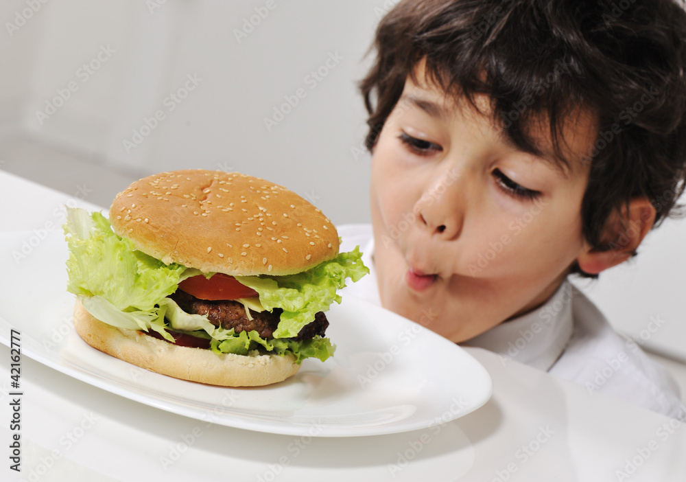 Kid on temptation with delicious hamburger Kid on temptation with delicious hamburger