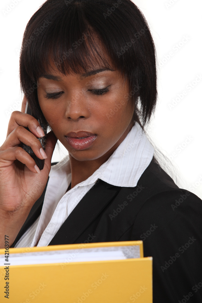 gorgeous black businesswoman on the phone holding folder gorgeous black businesswoman on the phone holding folder