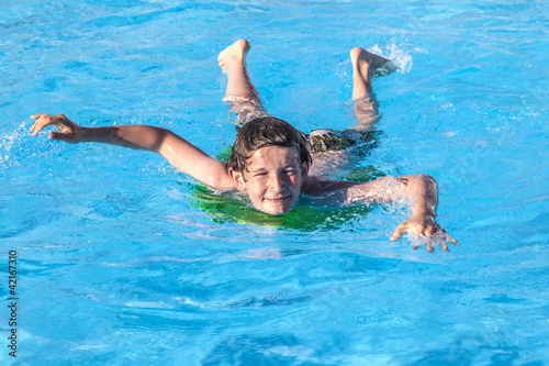 boy relaxing on a surfboard in the pool