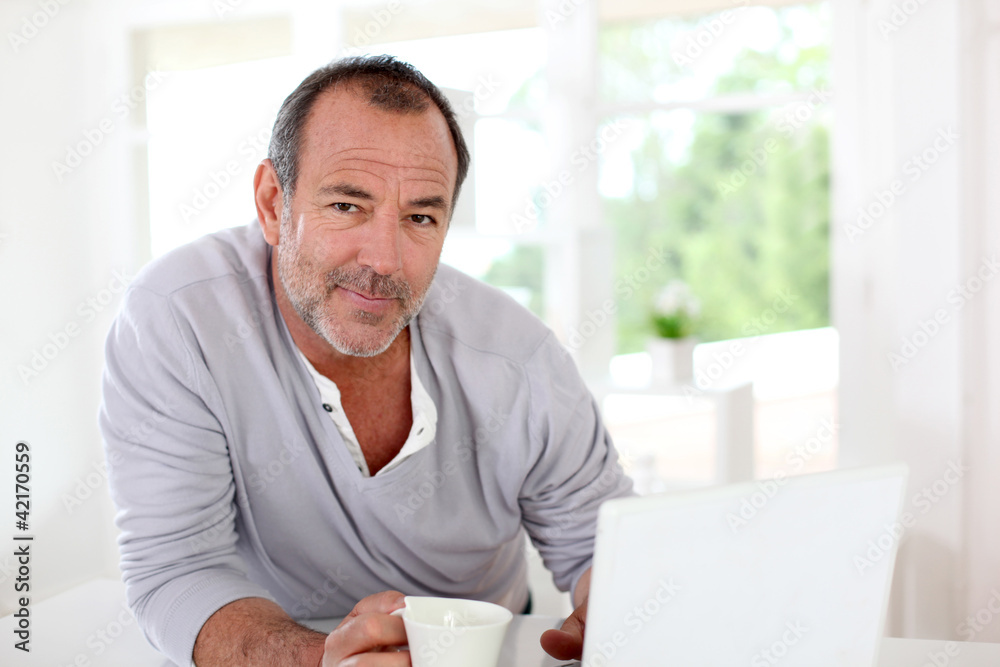 Senior man connected on internet with laptop at home Senior man connected on internet with laptop at home