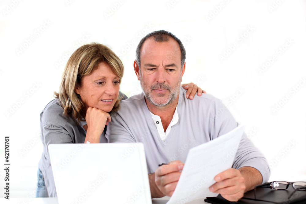 Senior couple at home declaring income on internet Senior couple at home declaring income on internet