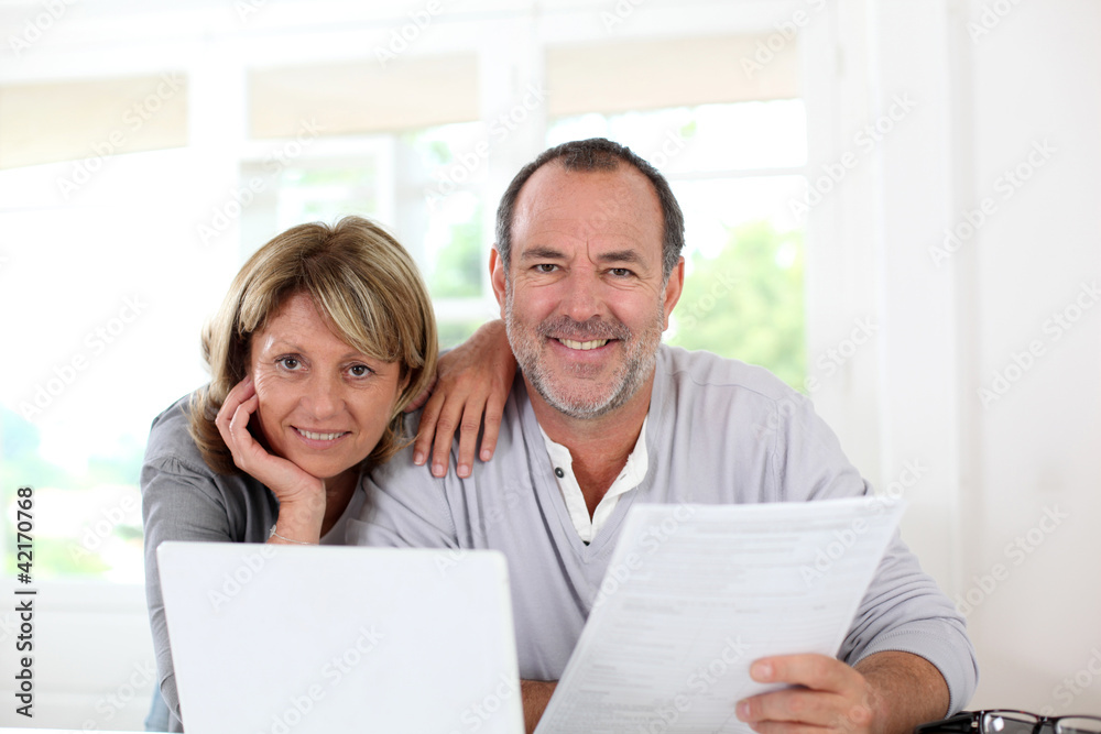 Senior couple at home declaring income on internet Senior couple at home declaring income on internet
