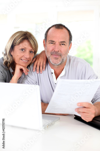 Senior couple at home declaring income on internet