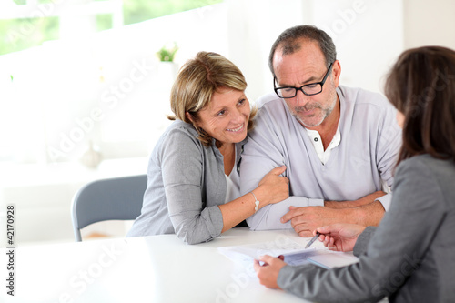 Senior couple signing financial contract