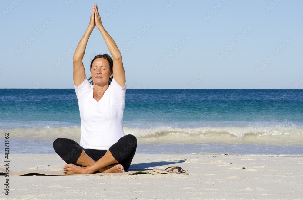 Meditating, relaxing, exercising woman at beach