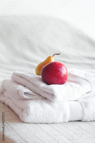 apple and pear on towels on the bed photo