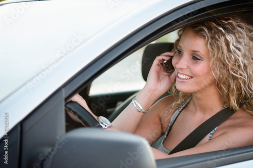 Portrait of young smiling person driving car © Martinan