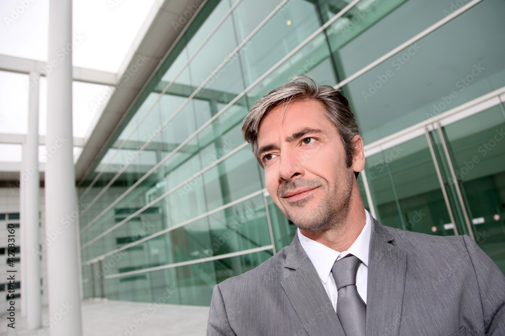 Portrait of businessman standing in front of modern building Portrait of businessman standing in front of modern building