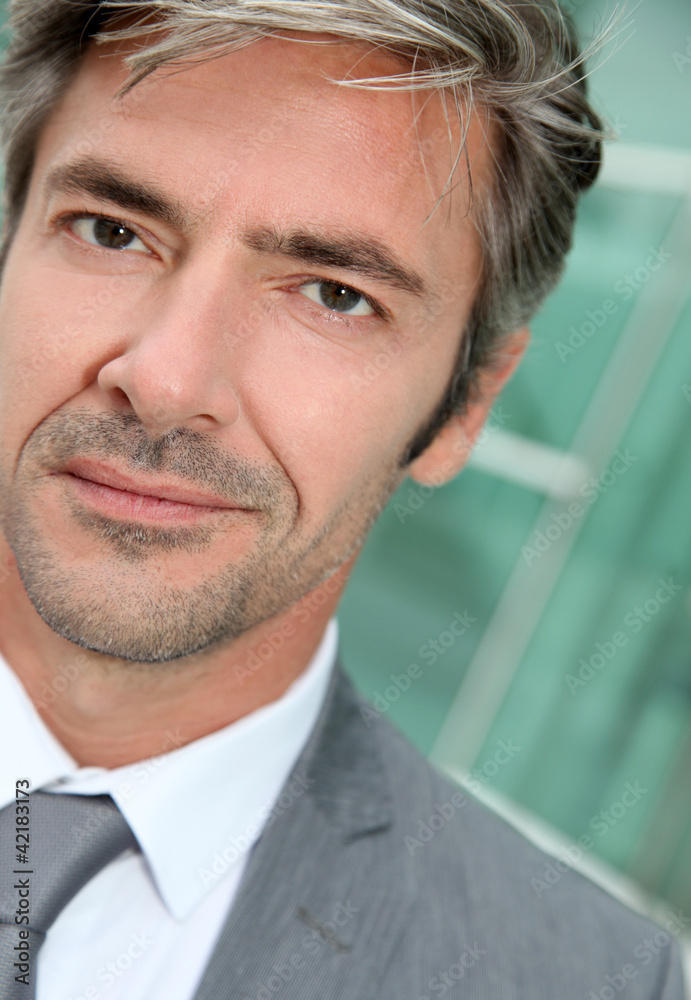 Portrait of businessman standing in front of modern building Portrait of businessman standing in front of modern building