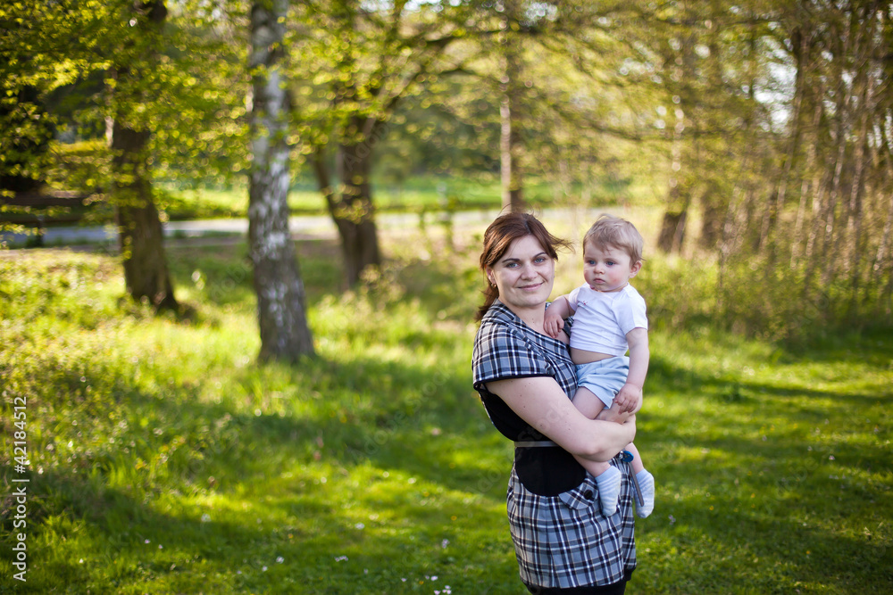 Young mother and toddler boy playing in the summer garden Young mother and toddler boy playing in the summer garden