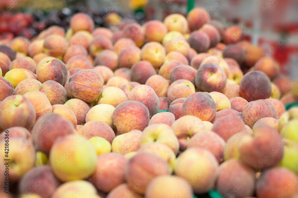 Variety of peaches in boxes in supermarket