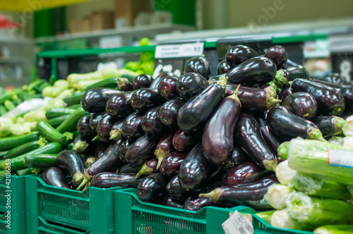 Variety of eggplants and Zucchini in boxes in supermarket