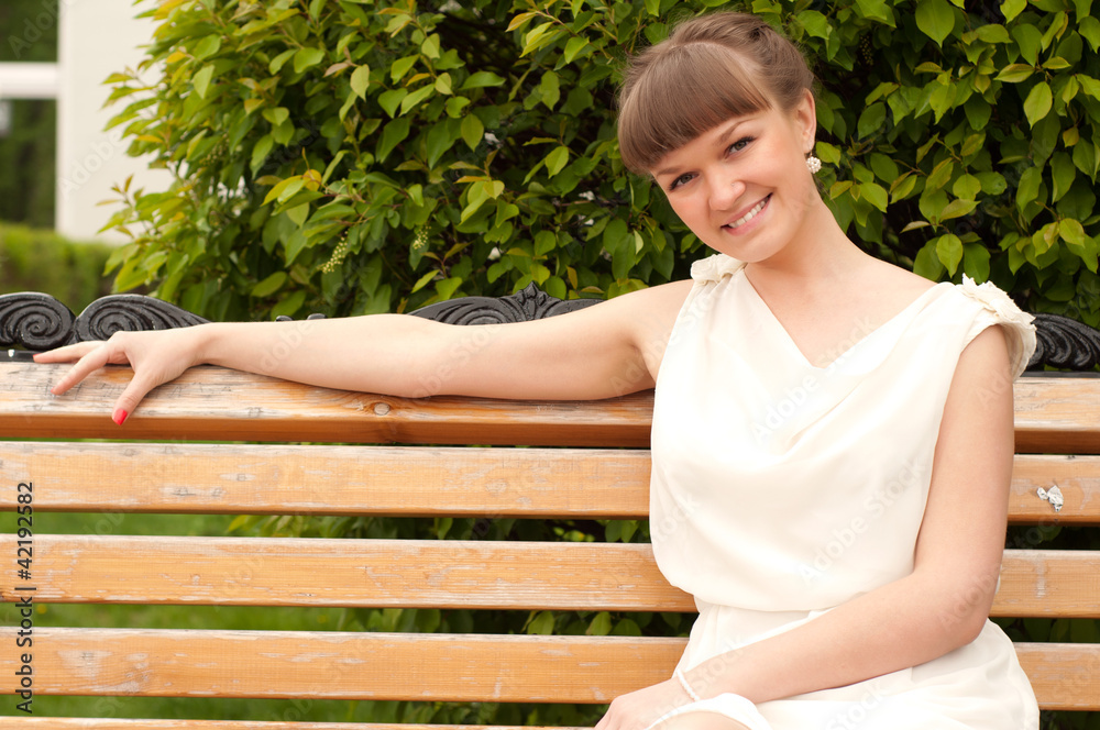A beautiful woman is sitting on a park bench A beautiful woman is sitting on a park bench