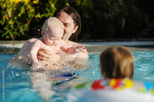 Father and daughter swimming in pool