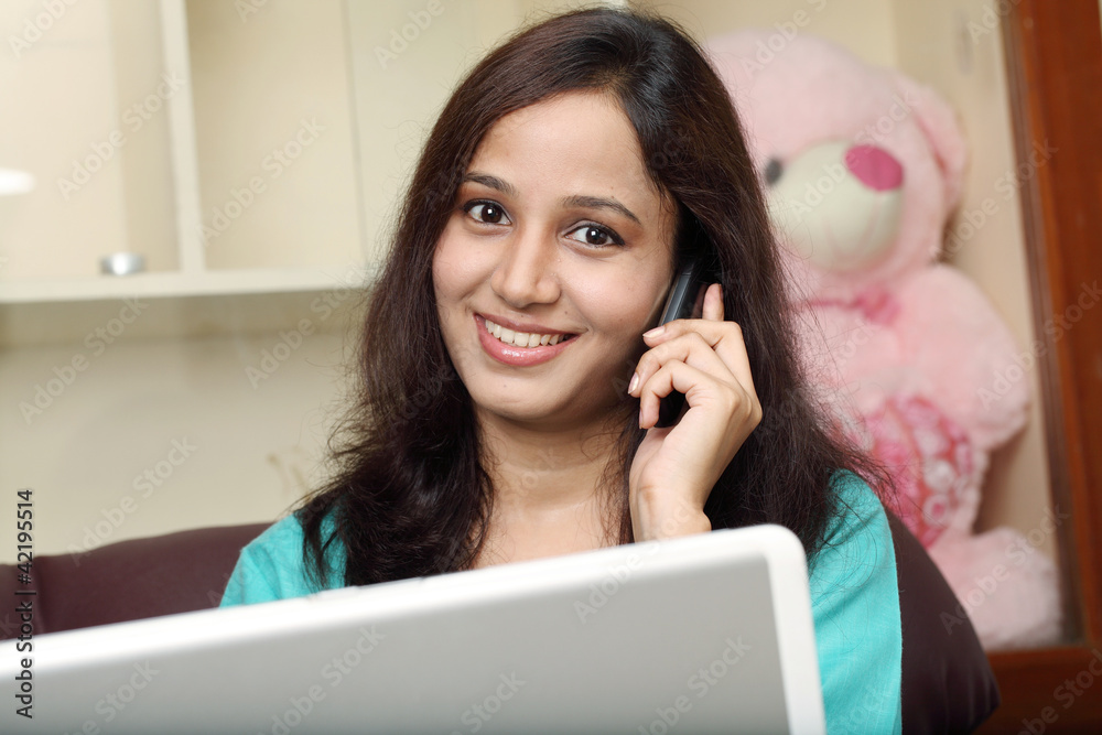 Happy woman with cellphone and laptop on sofa Happy woman with cellphone and laptop on sofa