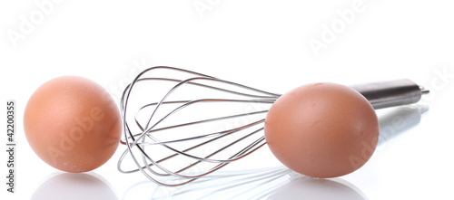 Fotografia Metal whisk for whipping eggs and brown eggs isolated on white