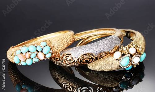 Beautiful golden bracelets on grey background photo