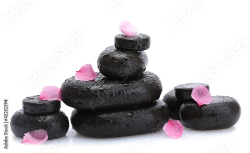 Spa stones with drops and pink sakura flowers isolated on white.