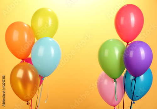 colorful balloons on yellow background close-up