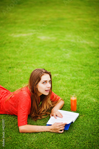 Young woman on the grass with book and orange juice © Mila Supinskaya 