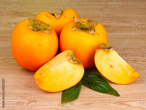 Appetizing persimmons on wooden background