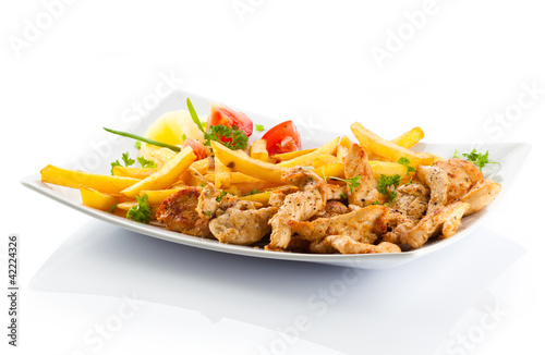 Grilled meat French fries and vegetables on white background