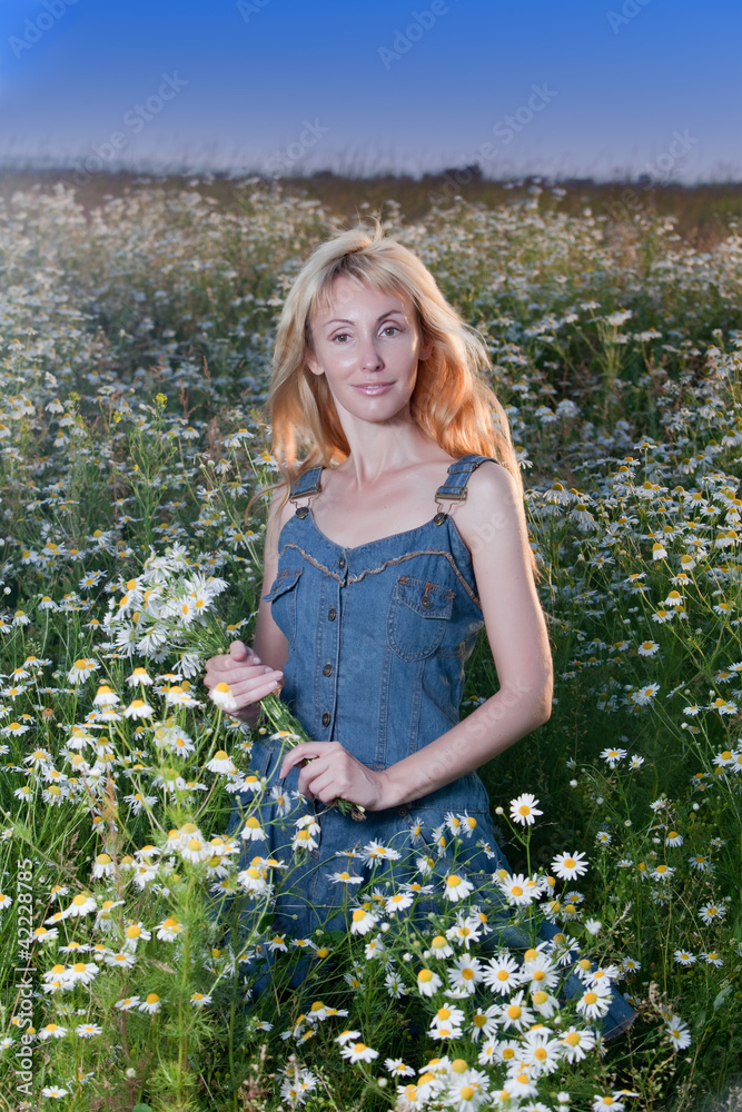 The happy young woman in the field of camomiles The happy young woman in the field of camomiles