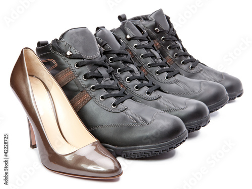 Men's boots and elegant female shoes on white background