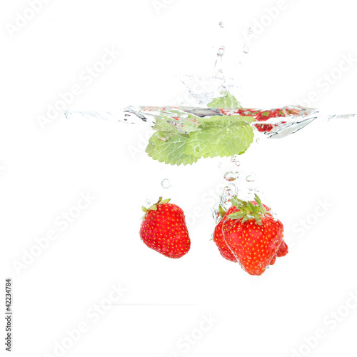 Erdbeeren mit Melisse fallen ins Wasser