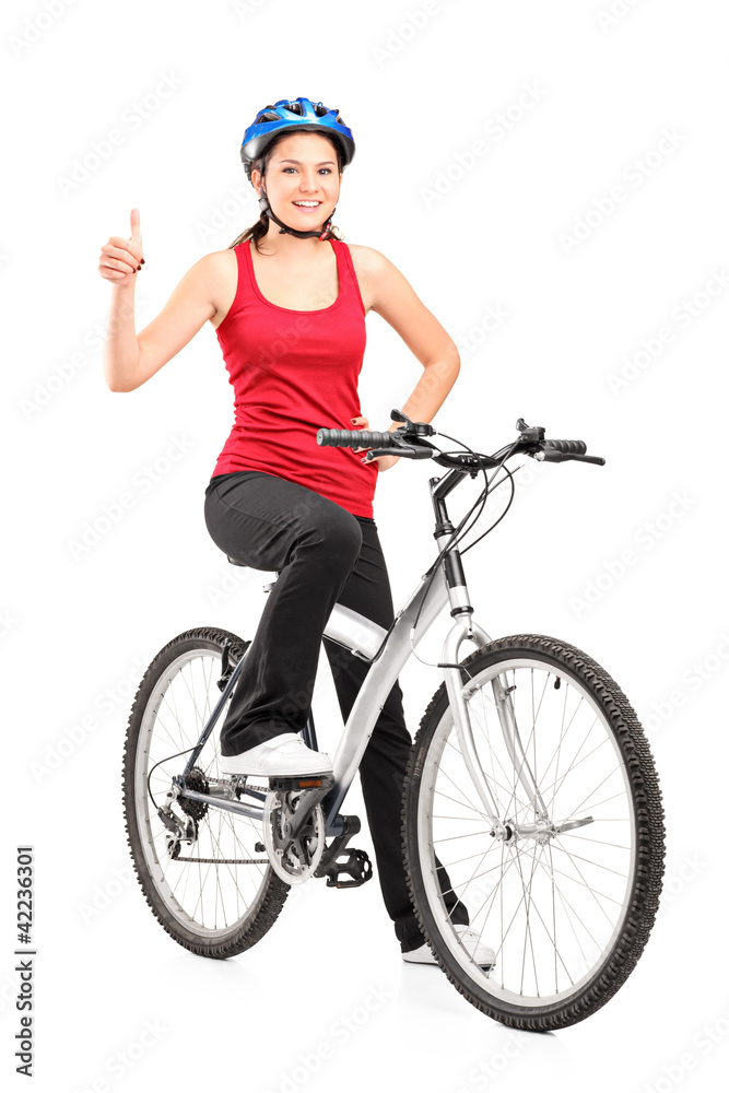 Female bicyclist posing on a bicycle and giving a thumb up Female bicyclist posing on a bicycle and giving a thumb up