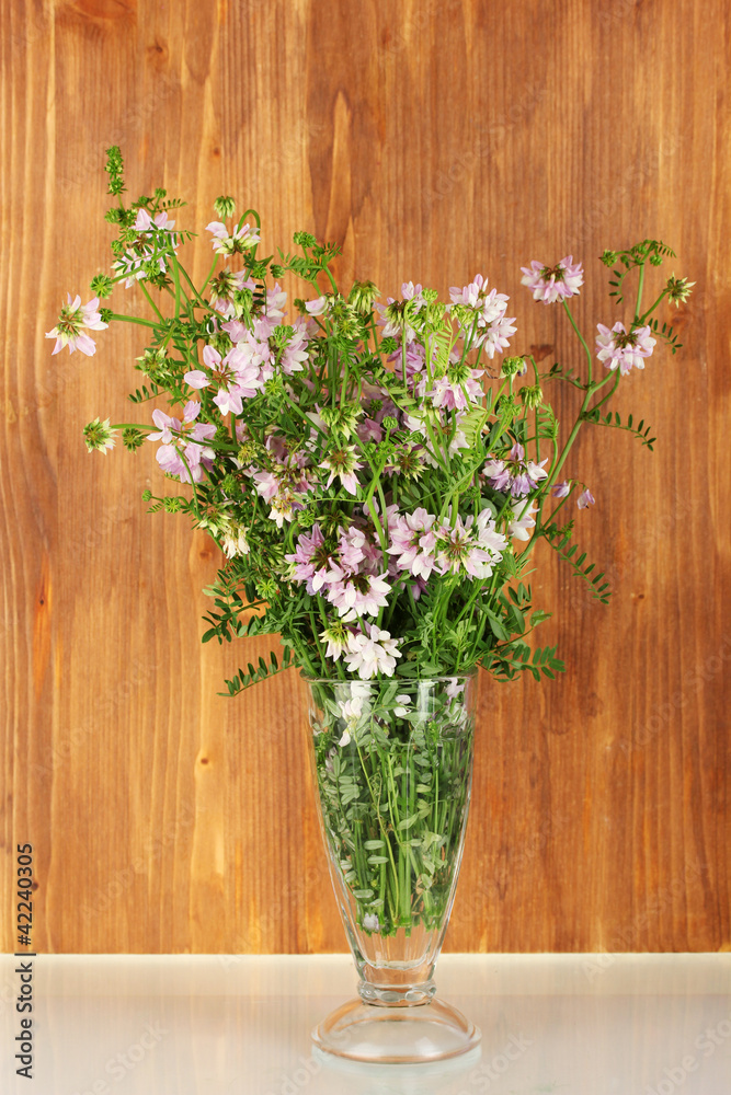 bouquet of vicia in a transparent vase on wooden background bouquet of vicia in a transparent vase on wooden background