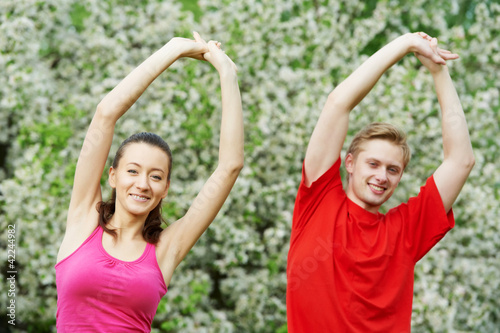Young man and woman doing stretching exercises