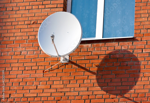 Slika na platnu Satellite Dish mounted on  brick wall.