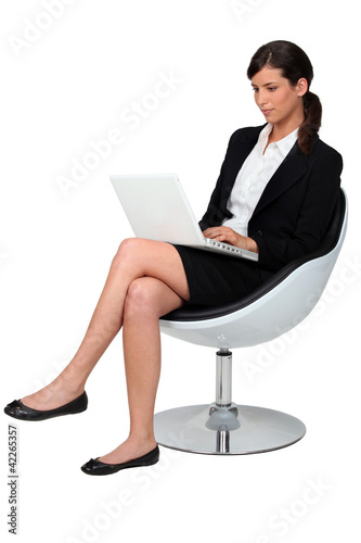 Businessman sat in chair with laptop