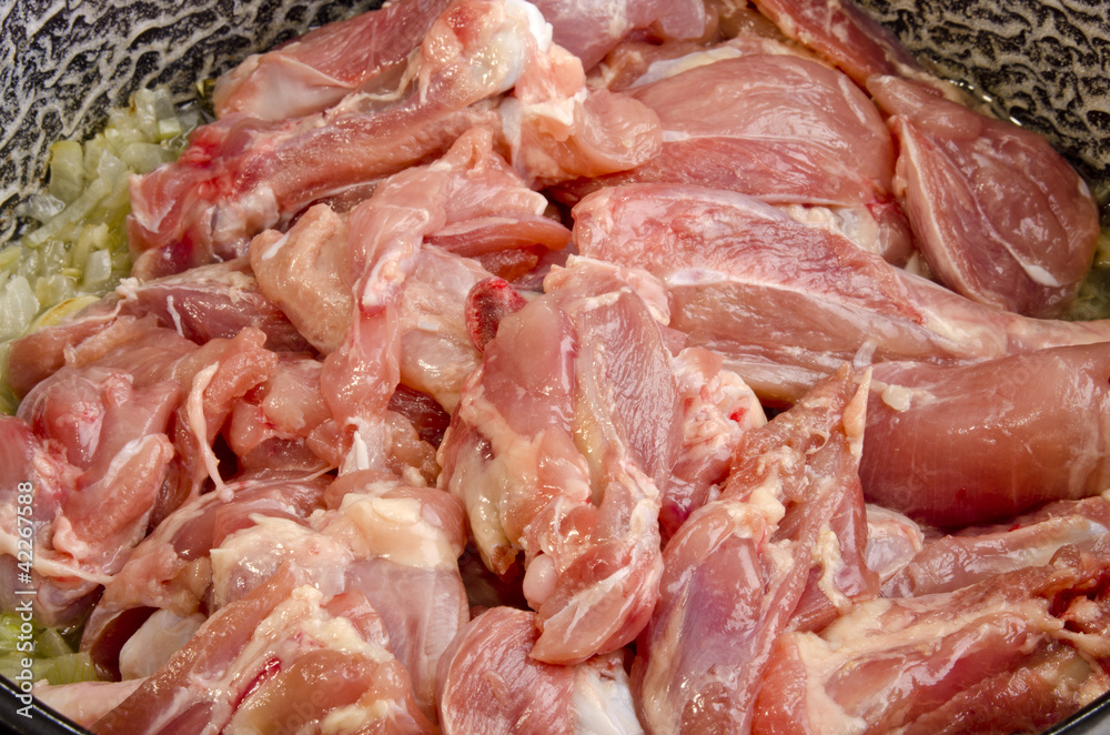 poultry parts in a pot with onions