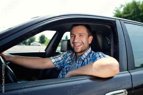 Young man in car smiling