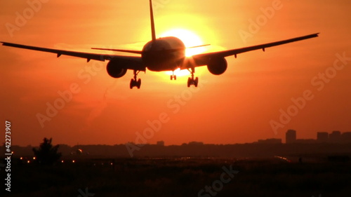 Plane crossing sun at sunrise