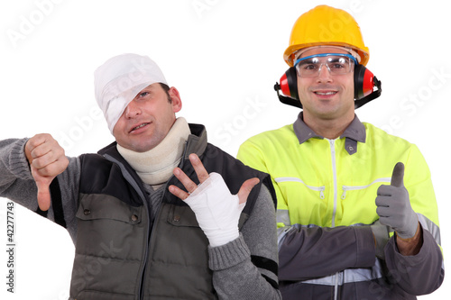 Healthy construction worker standing next to an injured man photo