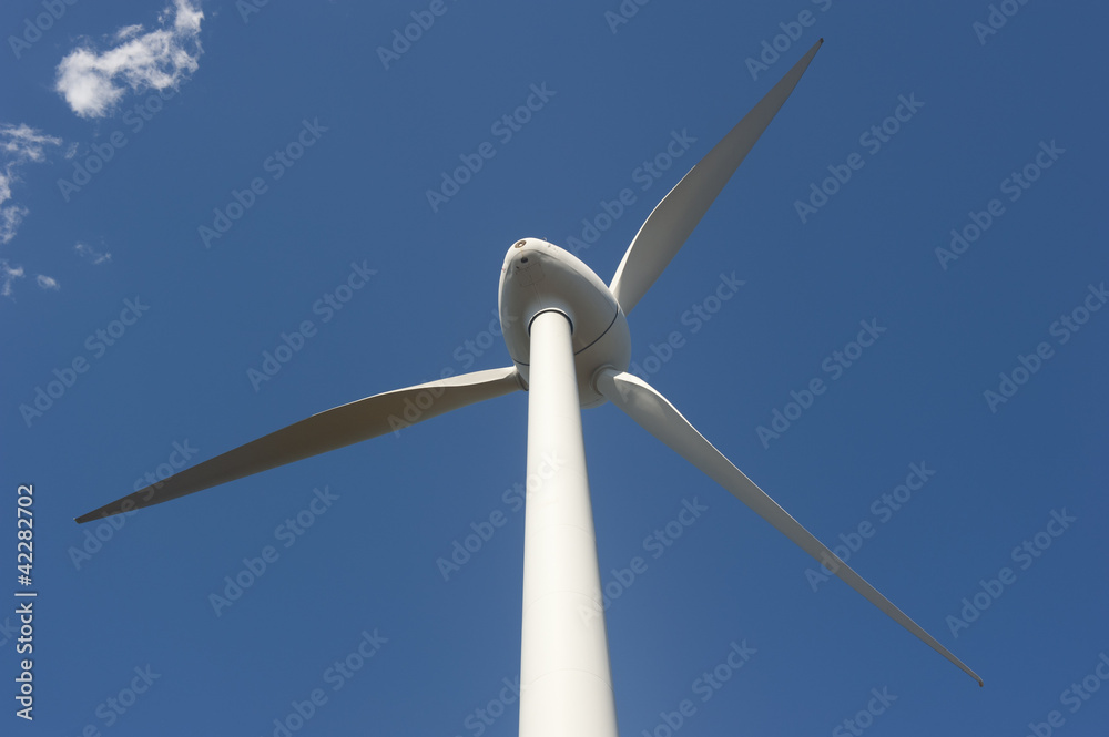 Upward view of windmill tower against sky background Upward view of windmill tower against sky background