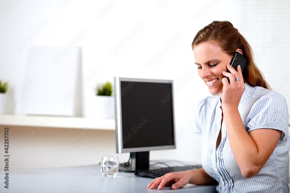 Friendly blonde secretary talking on cellphone Friendly blonde secretary talking on cellphone